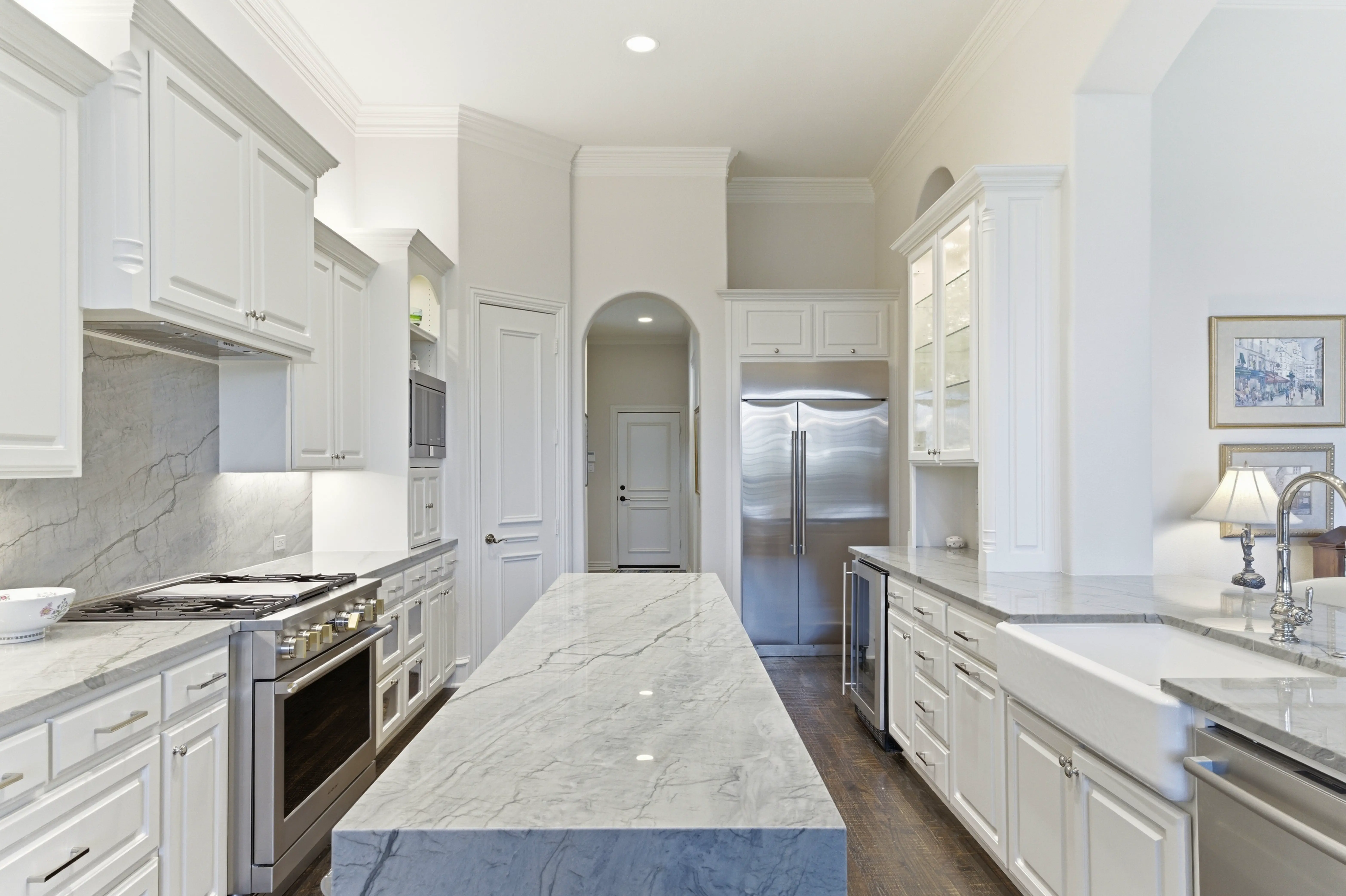 Chef's kitchen with quartzite waterfall island and white cabinetry